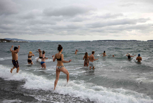 People gather for a traditional polar dip into the ocean at Willow's Beach in Victoria, B.C., on Saturday, January 1, 2022. (Photo by Chad Hipolito/The Canadian Press via AP)