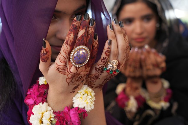 Muslim girls have their hands painted with traditional henna as they attend an Eid al-Fitr prayer, marking the end of the fasting month of Ramadan, at historical Badshahi mosque in Lahore, Pakistan, Wednesday, April, 10, 2024. (Photo by K.M. Chaudary/AP Photo)