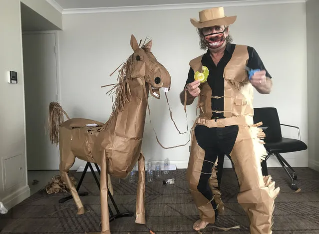 David Marriott poses with his paper horse in his hotel room in Brisbane, Australia, April 1, 2021. While in quarantine inside his Brisbane hotel room, art director Russell Brown was bored and started making a cowboy outfit from the paper bags his meals were being delivered in. His project expanded to include a horse and a clingfilm villain that he has daily adventures with, in images that have gained a huge online following. (Photo by David Marriott via AP Photo)