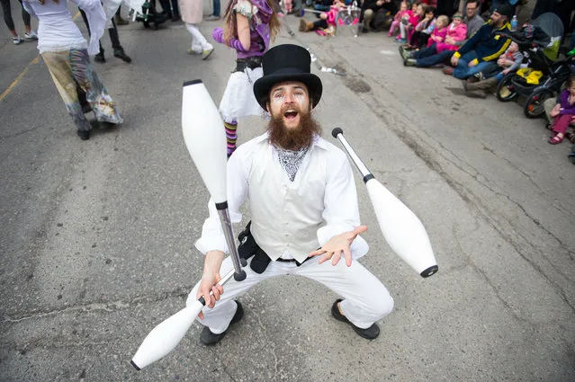 A man juggles during the 2014 FestiFools parade on South Main Street in downtown Ann Arbor, Mich., Sunday, April 6, 2014. (Photo by Courtney Sacco/AP Photo/The Ann Arbor News)