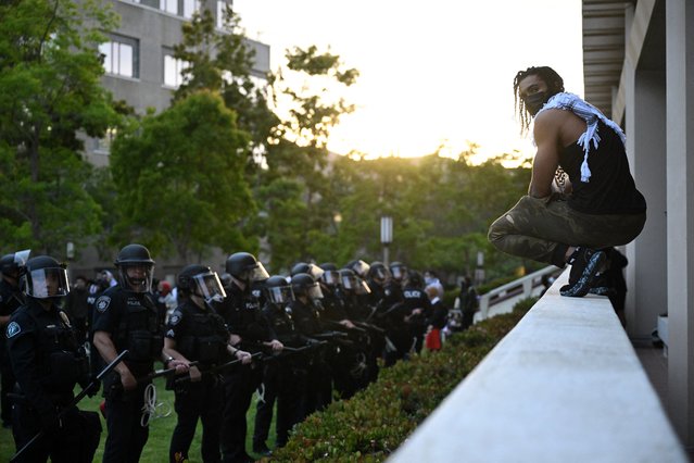 A pro-Palestinian demonstrator confronts police as they clear an encampment at the University of California, Irvine, in Irvine, California on May 15, 2025. (Photo by Patrick T. Fallon/AFP Photo)