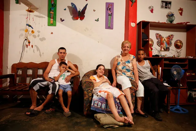 Alida Gonzalez (2nd R) poses for a picture next to her relatives (L-R) Manuel Garcia, Jesus Garcia, Maira Hernandez and Nixon Urbano, at their home in Caracas, Venezuela April 15, 2016. “With the money we used to spend on breakfast, lunch and dinner, we can now buy only breakfast - and not a very good one”, Gonzalez said. (Photo by Carlos Garcia Rawlins/Reuters)