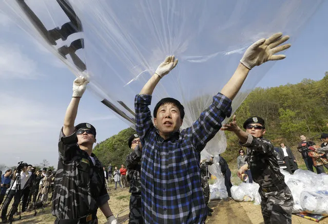 North Korean defectors prepare to release balloons carrying leaflets condemning North Korean leader Kim Jong Un during a rally against North Korea in Paju, near the border with North Korea, South Korea, Friday, April 29, 2016. North Korea on Friday accused U.S. soldiers of trying to provoke its frontline troops with “disgusting” acts and encouraging South Korean soldiers to aim their guns at the North. (Photo by Ahn Young-joon/AP Photo)