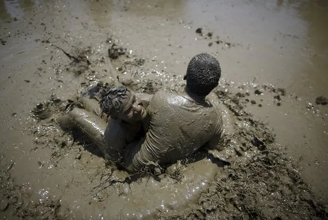 Participants play on the mud during the Asar Pandhra festival in Pokhara valley, west of Nepal's capital Kathmandu, June 30, 2015. (Photo by Navesh Chitrakar/Reuters)