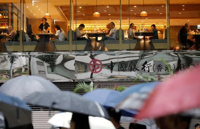 People are seen inside a restaurant as anti-extradition bill protesters take part in the march to demand democracy and political reforms in Hong Kong, China, August 18, 2019. (Photo by Kim Hong-Ji/Reuters)