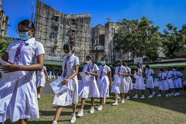 Schoolgirls in the 12-15 year age group queue up to get themselves inoculated with the jab of Pfizer-BioNTech vaccine against the Covid-19 coronavirus at an educational institution in Colombo on January 7, 2022. (Photo by Ishara S. Kodikara/AFP Photo)