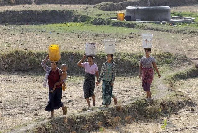 Myanmar women carrying buckets on their heads collect drinking water from the outskirts of Naypyitaw, Myanmar, 25 April 2016. Myanmar might suffer from drought and drinking water shortages in at least 10 regions, in the summer of 2016, due to the El Nino weather phenomenon, according to the Department of Meteorology and Hydrology (DMH) of Myanmar. (Photo by Hein Htet/EPA)