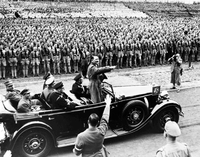 German Chancellor Adolf Hitler stands in his car and salutes thousands of Hitler Youth at the Post Stadium, Berlin, May, 1, 1936, where he will address the massed crowd as part of the May Day Celebrations. As one of the most notorious tyrants in world history, Hitler helped form the Nazi Party in 1919. He became the dictator of Germany in 1933, and launched the holocaust as a “final solution” to the “Jewish problem” as well as gypsies and homosexuals. In 1939, he invaded Poland and began World War II which ravaged Europe. The Fuhrer of the Third Reich committed suicide on April 30, 1945, with his mistress, Eva Braun. (Photo by AP Photo)