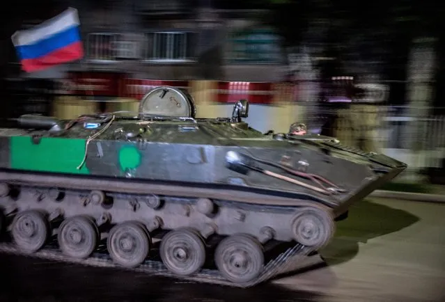 An Armoured Personnel Carrier (APC) with a Russian flag drives through the center of Slaviansk during the day of referendum organized by the so-called Donetsk People's Republic members, in Slaviansk, Ukraine, 11 May 2014. Residents of eastern Ukraine on 11 May were voting in an independence referendum that was organized by pro-Russian separatists and rejected by the government in Kiev. (Photo by Roman Pilipey/EPA)