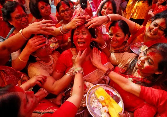 A Hindu woman reacts as “Sindhur”, or vermillion powder, is applied to her face after worshipping an idol of the Hindu goddess Durga on the last day of the Durga Puja festival in Chandigarh, India, October 8, 2019. (Photo by Ajay Verma/Reuters)