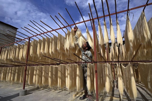 A worker prepares traditional vermicelli noodles, a favorite during the Muslim holy fasting month of Ramadan, at a factory, in Karachi, Pakistan, Monday, April 10, 2023. (Photo by Fareed Khan/AP Photo)