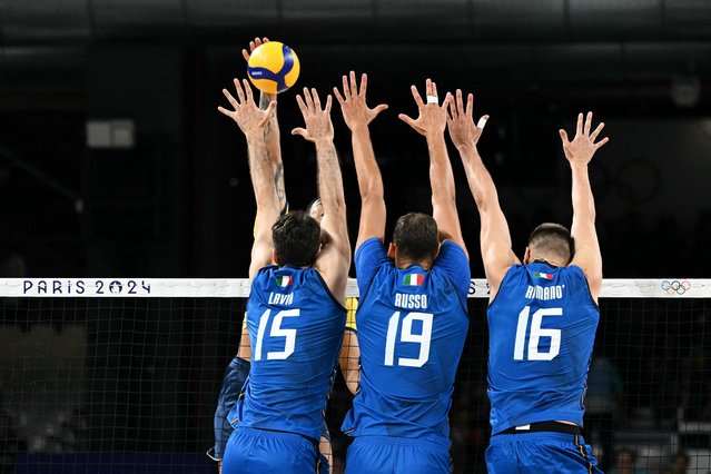 (LtoR) Italy's #15 Daniele Lavia, Italy's #19 Roberto Russo and Italy's #16 Yuri Romano jump to block the ball during the men's preliminary round volleyball match between Italy and Brazil during the Paris 2024 Olympic Games at the South Paris Arena 1 in Paris on July 27, 2024. (Photo by Natalia Kolesnikova/AFP Photo)