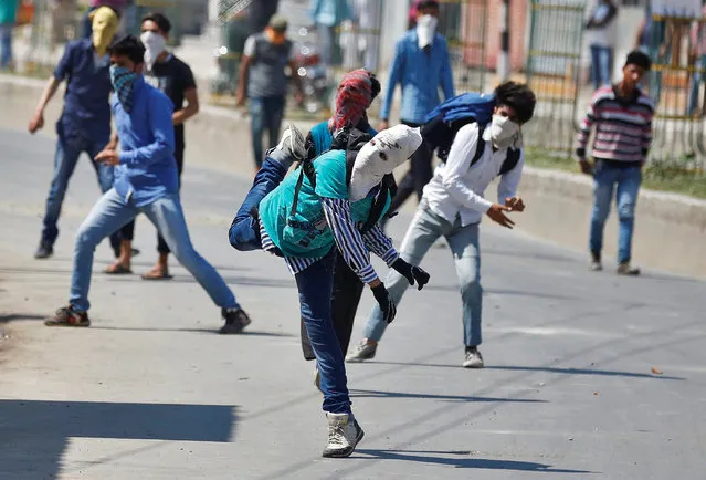 Masked Kashmiri protesters throw stones towards Indian security personnel during a demonstration against the plan to resettle Hindus in the valley, according to local media, in Srinagar May 27, 2016. (Photo by Danish Ismail/Reuters)