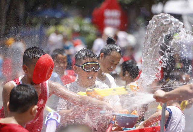 Children splash water to celebrate Water Dragon Carnival on July 21, 2024 in Shibing County, Qiandongnan Miao and Dong Autonomous Prefecture, Guizhou Province of China. (Photo by Mo Guibin/VCG via Getty Images)