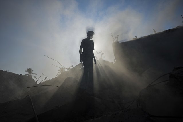 A Palestinian child inspects the rubble of a school destroyed in an Israeli airstrike on Deir al-Balah, central Gaza Strip, Saturday, July 27, 2024. (Photo by Abdel Kareem Hana/AP Photo)