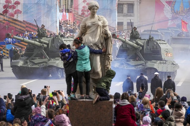 People look at self-propelled artillery vehicles Msta-S rolling during the Victory Day military parade at the Dvortsovaya (Palace) Square in St. Petersburg, Russia, Monday, May 9, 2022. (Photo by Dmitri Lovetsky/AP Photo)