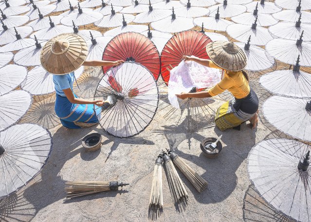 Women in Pathein, Myanmar, construct in the last decade of August 2024 parasols that they will paint in vibrant colours to sell in nearby markets. (Photo by Nantapon Pattamakijsakul/Solent News)