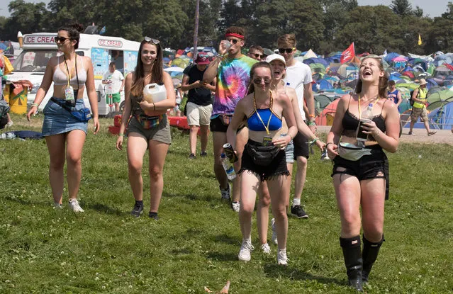 A group of recently arrived festival goers look for shade as temperatures reach record levels at the Glastonbury Festival at Worthy Farm in Pilton on June 21, 2017 near Glastonbury, England. (Photo by Matt Cardy/Getty Images)
