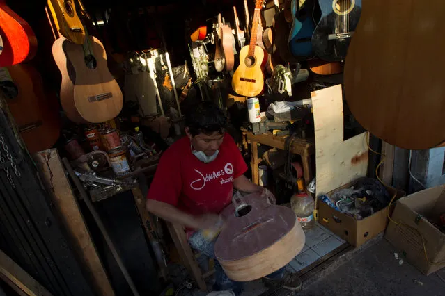 Ecuadorian luthier Ivan Ibujes prepares a guitar to be repaired at his shop in Quito, June 17, 2016. (Photo by Guillermo Granja/Reuters)