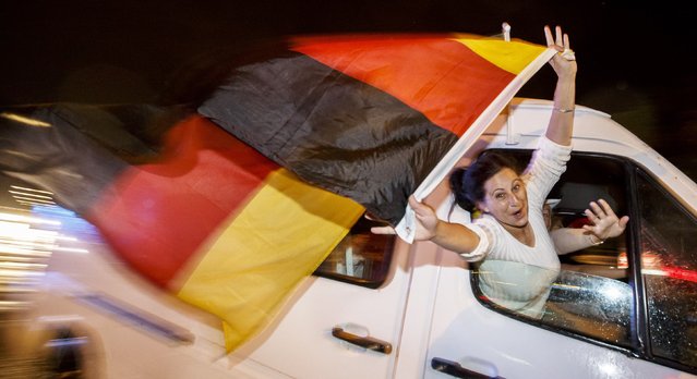 German fans celebrate as they drive along the “Reeperbahn” red light district in Hamburg after Germany won the World Cup soccer final against Argentina, July 13, 2014. (Photo by Morris Mac Matzen/Reuters)