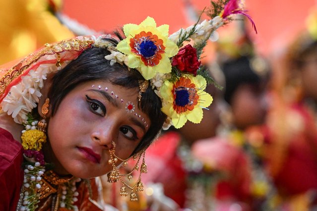 A young girl dressed as Hindu Goddess “Durga” sits near the deity's idol during the traditional “Kumari Puja” as a part of the Durga Puja festival in Kolkata on October 11, 2024. (Photo by Dibyangshu Sarkar/AFP Photo)