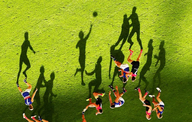 Long shadows are cast by players as Mitch Wallis of the Bulldogs passes the ball during the 2016 AFL Round 08 match between the Melbourne Demons and the Western Bulldogs at the Melbourne Cricket Ground, Melbourne on May 15, 2016. (Photo by Scott Barbour/AFL Media/Getty Images)