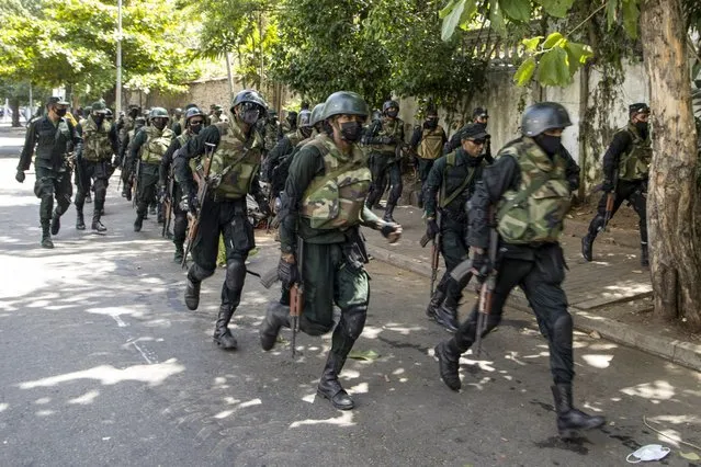 Military officers make their way to an anti-government protest at the prime minister's office in Colombo, Sri Lanka, on Wednesday, July 13, 2022. The state of emergency was imposed by acting president Prime Minister Ranil Wickremesinghe as police clash with protesters after President Rajapaksa has fled the island nation. The leadership vacuum may delay bailout talks with IMF. (Photo by Buddhika Weerasinghe/Bloomberg)