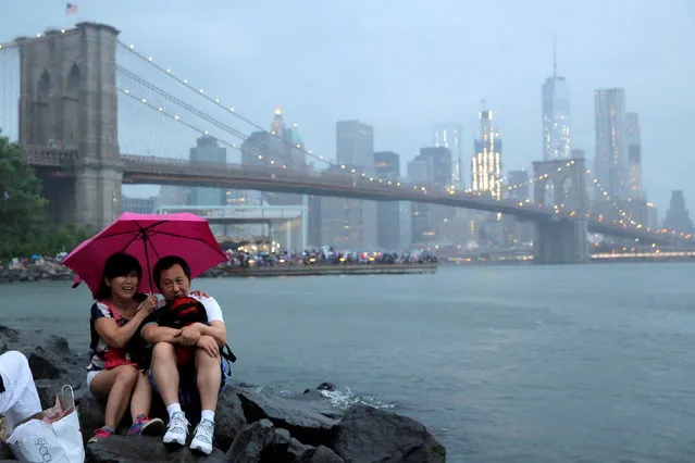 People wait for the Macy's 4th of July Fireworks on the East River as it rains in New York, U.S., July 4, 2016. (Photo by Andrew Kelly/Reuters)