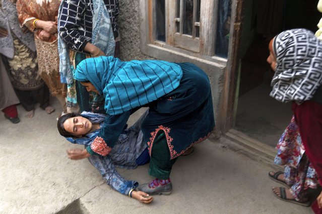 A woman tends to a relative of Mushtaq Ahmad, an army porter who was among those killed in a rebel ambush on an army vehicle on Thursday night, during his funeral in Nowshera village north of Srinagar, Indian controlled Kashmir, Friday, October 25, 2024. (Photo by Dar Yasin/AP Photo)