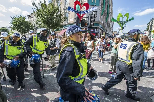 Riot police pass by the Grenfell quiet area after the minutes silence at Notting Hill Carnival 2017 on August 27, 2017 in London, England. (Photo by Guy Bell/Rex Features/Shutterstock)