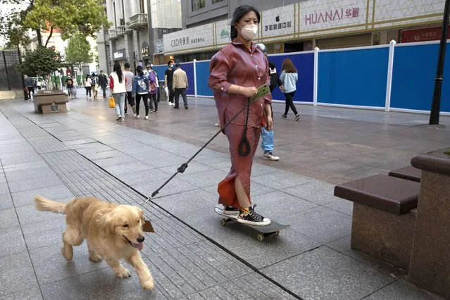A resident gets a ride from her dog along a retail street in Wuhan in central China's Hubei province, Thursday, April 9, 2020. (Photo by Ng Han Guan/AP Photo)