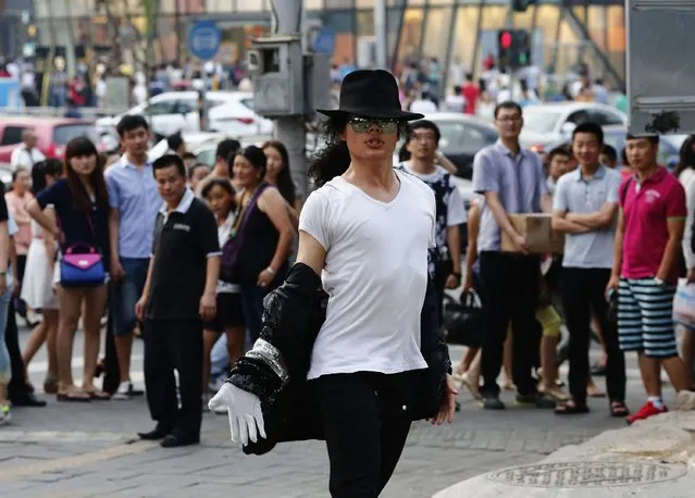 Zhang Guanhui, impersonating Michael Jackson, dances during his street performance in Beijing August 20, 2014. (Photo by Kim Kyung-Hoon/Reuters)