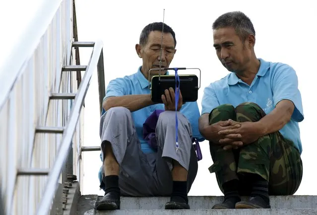 Security volunteers watch a video related to the parade near the Changan Avenue, ahead of the military parade to mark the 70th anniversary of the end of World War Two, in Beijing, China, September 3, 2015. (Photo by Kim Kyung-Hoon/Reuters)