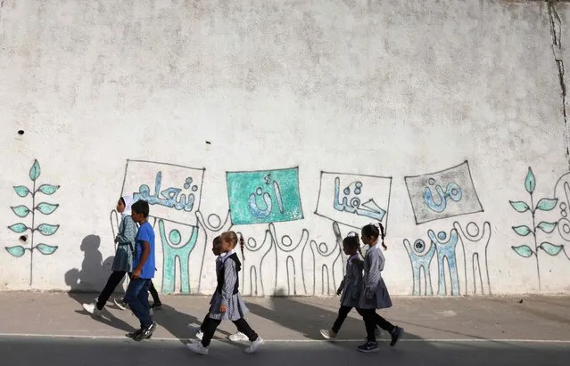 Palestinian pupils walk to class on the first day of the academic new year at their school in al-Tuwani village, near Hebron city in the occupied West Bank, on August 29, 2022. (Photo by Hazem Bader/AFP Photo)