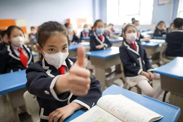 Students wearing face masks attend an epidemic prevention and control drill at Xinjianlu primary school in preparation for its reopening on May 18, 2020 in Taiyuan, Shanxi Province of China. (Photo by Zhang Yun/China News Service via Getty Images)