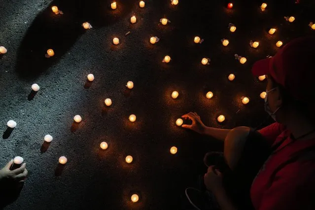 Human rights groups lights candles as they mark the 50th anniversary of martial law at the University of the Philippines in Metro Manila, Philippines, Wednesday, September 21, 2022. Survivors of torture and other atrocities under Philippine dictator Ferdinand Marcos on Wednesday marked his martial law declaration 50 years ago by pressing their demand for justice and apology from his son, now the country's president in a stunning reversal of fortunes for the once reviled family. (Photo by Aaron Favila/AP Photo)