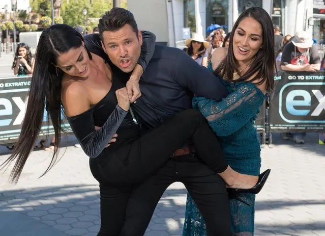 Nikki Bella and Brie Bella wrestle Mark Wright at “Extra” at Universal Studios Hollywood on October 26, 2017 in Universal City, California. (Photo by Noel Vasquez/Getty Images)
