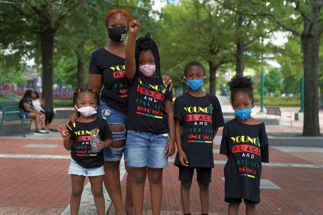 A woman and children wearing face masks pose for a picture as people take part in an event to mark Juneteenth, which commemorates the end of slavery in Texas, two years after the 1863 Emancipation Proclamation freed slaves elsewhere in the United States, amid nationwide protests against racial inequality, in Atlanta, Georgia, U.S. June 19, 2020. (Photo by Elijah Nouvelage/Reuters)