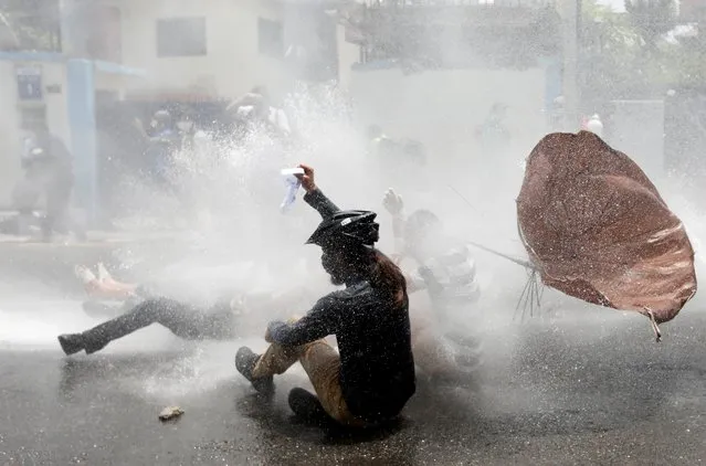 Protesters get hit by a water cannon during a protest near the Prime Minister's official residence, demanding better and effective response from the government to fight the coronavirus disease (COVID-19) outbreak as the number of infections spikes, in Kathmandu, Nepal on June 9, 2020. (Photo by Navesh Chitrakar/Reuters)