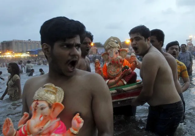 Devotees carry idols of the Hindu god Ganesh, the deity of prosperity, into the Arabian Sea on the fifth day of the ten-day-long Ganesh Chaturthi festival in Mumbai, India, September 21, 2015. (Photo by Danish Siddiqui/Reuters)