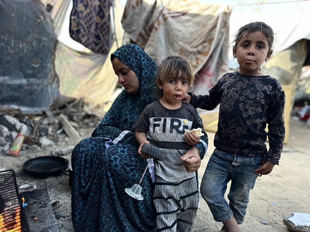 Members of the Fujo family, who have taken refuge in a makeshift tent near the cemetery in the Austrian neighborhood, are struggling to survive their daily lives in harsh living conditions while being deprived of the most basic needs such as food and clean water in Khan Yunis, Gaza on April 10, 2025. The children of the Gazan family grow up amidst the sounds of gunfire and bombs in a war zone. (Photo by Doaa Albaz/Anadolu via Getty Images)
