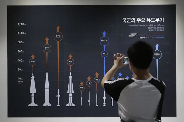 A visitor takes a picture of a display board showing major guide weapons of the South Korean armed forces at Korea War Memorial Museum in Seoul, South Korea, Tuesday, July 28, 2020. South Korea said Tuesday it has won U.S. consent to use solid fuel for space launch vehicles, a move that experts say would enable Seoul to launch its first surveillance satellites and accumulate technology to build more powerful missiles. (Photo by Ahn Young-joon/AP Photo)