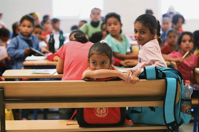 Syrian students watch German Economy Minister Sigmar Gabriel as he visits the classroom at the Zaatari refugee camp near Mafraq, north of Amman, Jordan, Tuesday, September 22, 2015. (Photo by Raad Adayleh/AP Photo)