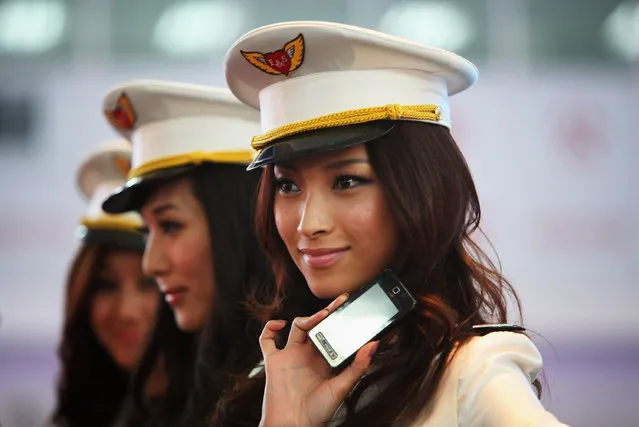 Chinese models show the new types of 3G mobile phones at the P&T/Wireless & Networks Comm China, the largest telecom event in Asia, in Beijing, China.  (Photo by Feng Li)