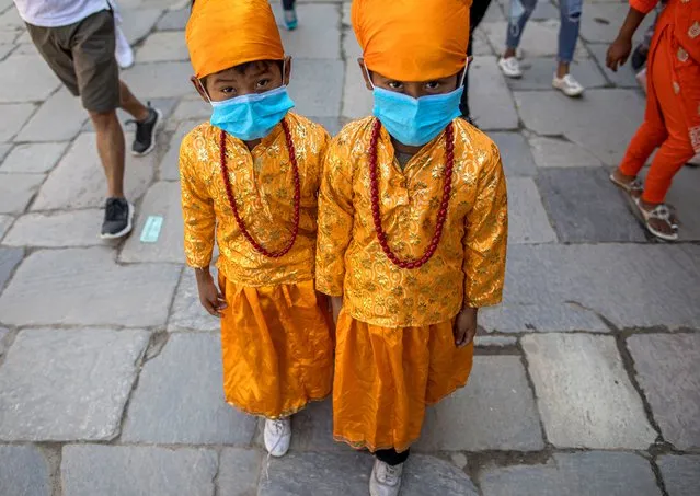Nepalese children wear facial masks with festive costumes as they take part in the Gai Jatra (Cow Festival) procession, amid the coronavirus pandemic, in Kathmandu, Nepal, 04 August 2020. Nepalese Hindus celebrate the religious festival to ask for salvation and peace for their family members who have passed away. Children participating in the procession often dress as cows, which are regarded as holy animals in Nepal, and according to belief help departed souls to reach heaven. (Photo by Narendra Shrestha/EPA/EFE)
