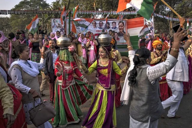 Artists dance as people watch from the sidewalks while Rahul Gandhi march with his supporters in New Delhi, India, Saturday, December 24, 2022. (Photo by Altaf Qadri/AP Photo)
