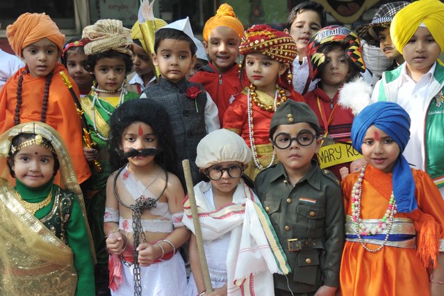 Indian schoolchildren, some of them dressed up as India's first prime minister Jawaharlal Nehru (top 3rd L), Indian queen warrior Lakshmibai, the Rani of Jhansi (top 3rd R), Mangal Pandey Subhas (bottom 2nd L), Mahatma Gandhi (C), and Chandra Bose (2nd R) pose during a fancy dress competition for Children's Day celebrations at a school in Amritsar, India's northwestern state of Punjab, on November 14, 2014. (Photo by Narinder Nanu/AFP Photo)