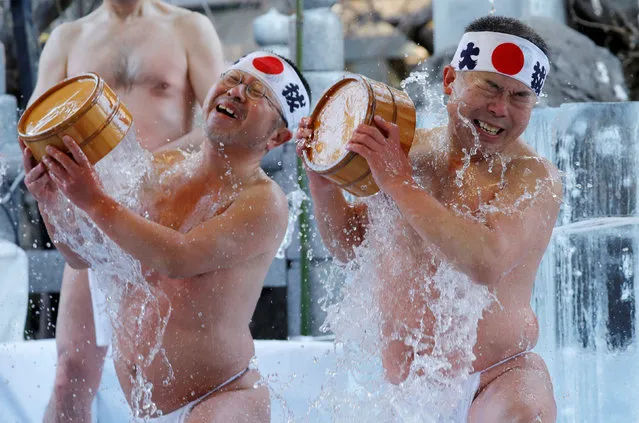 Men splash themselves with cold water during the annual cold water endurance ceremony, to purify their souls and wish for good fortune in the new year, at the Kanda Myojin shrine in Tokyo, Japan January 13, 2018. (Photo by Kim Kyung-Hoon/Reuters)