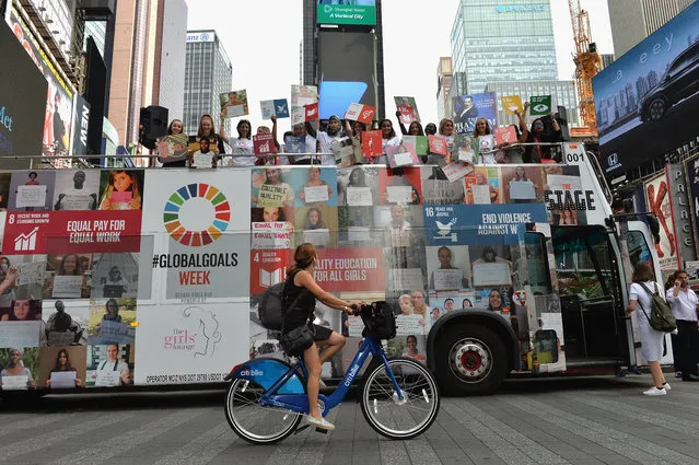 Women hold global goals signs on top of the 2016 Global Goals Girls Bus in Times Square on September 20, 2016 in New York City. (Photo by D. Dipasupil/Getty Images for Global Goals)