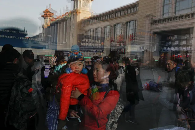 Passengers are reflected in the widow of a ticket booth at the Beijing Railway Station as the annual Spring Festival travel rush begins ahead of the Chinese Lunar New Year, in central Beijing, China on February 1, 2018. (Photo by Damir Sagolj/Reuters)
